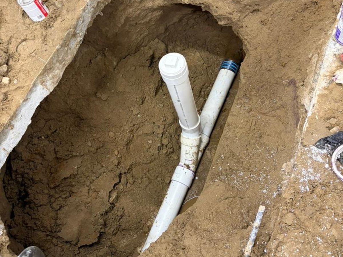 New PVC sewer cleanout installed in an open excavation by Drain Polishers